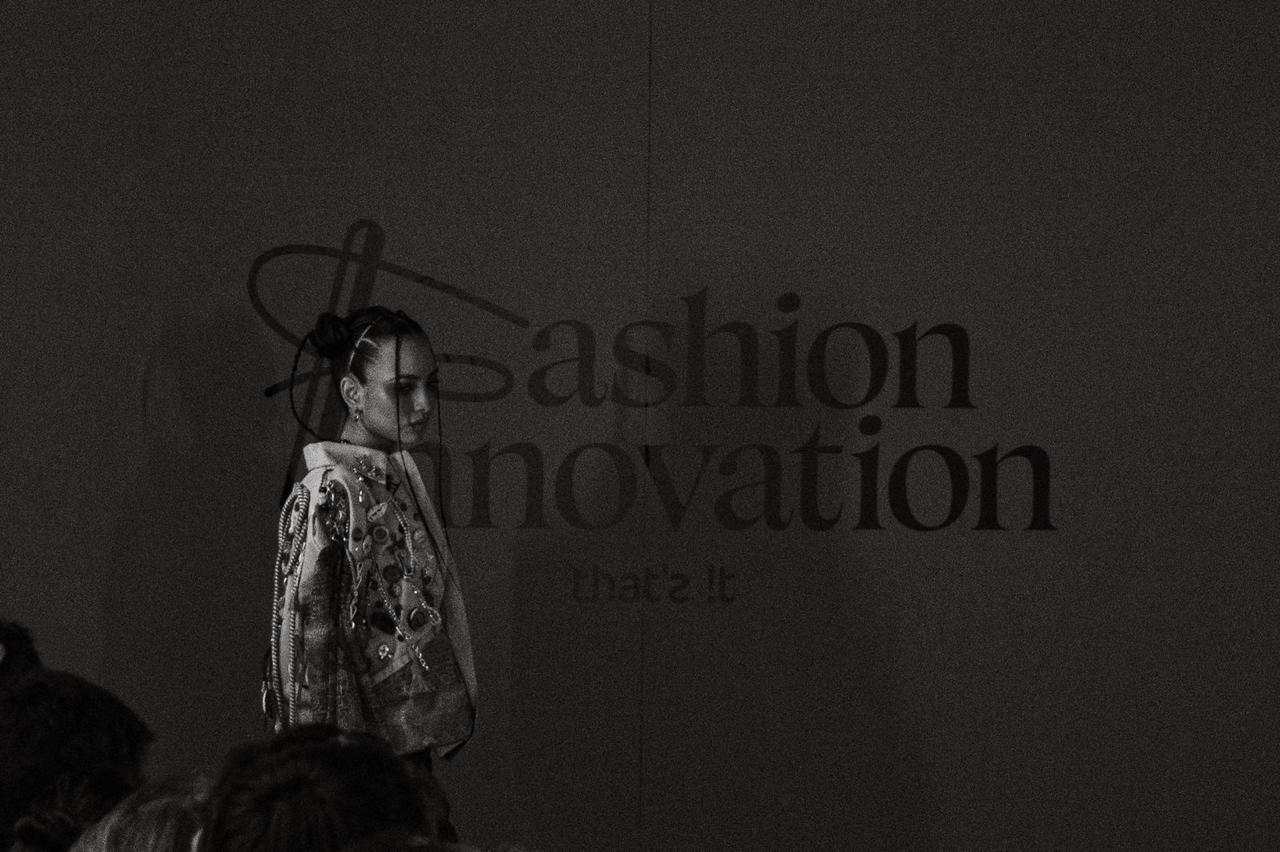Modelo desfilando la colección Reconecto frente al letrero “Fashion Innovation” del programa realizado con Liverpool.